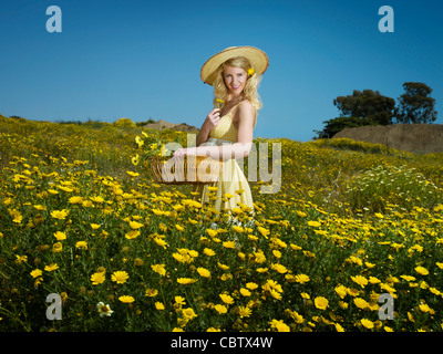 Kaukasische Frau Kommissionierung Wildblumen im Feld Stockfoto