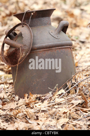 Eine alte verrostete Milch kann mitten im Wald verlassen und rustikal. Stockfoto