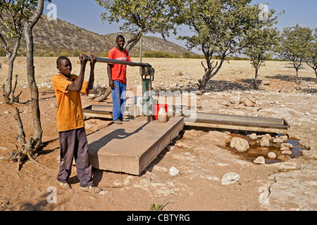 Herero Jungs immer Wasser von öffentlichen Pumpe, Damaraland, Namibia Stockfoto