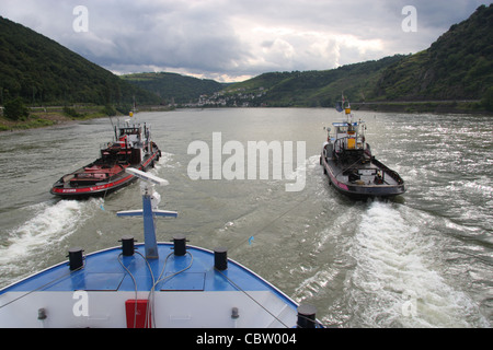 Schlepptau Boote verleihen Unterstützung zu einem Fluss Kreuzfahrt Boot auf dem Rhein stromaufwärts der Loreley, Deutschland Stockfoto