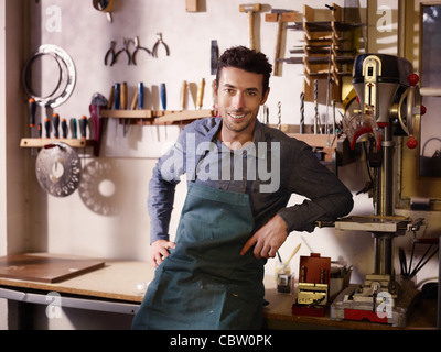 Porträt von Erwachsenen italienischen Mann bei der Arbeit als Handwerker im Shop mit Werkzeugen im Hintergrund Stockfoto