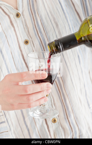 Frau roten Wein in ein Glas gießen Stockfoto