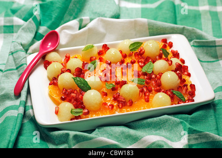 Mandarinen mit Melone und Granatapfel. Rezept zur Verfügung. Stockfoto