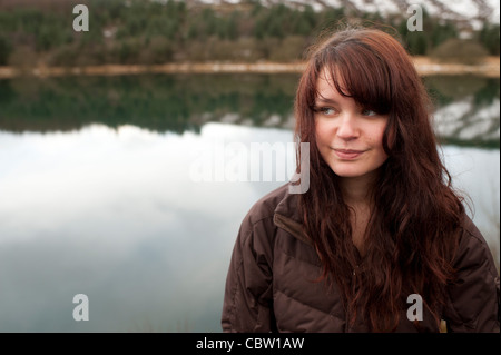 Ein 16 Jahre alten braun behaarte Teenager-Mädchen, im Freien, an einem See, Winternachmittag, UK Stockfoto