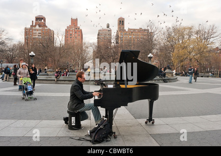 New York, NY - 22 Dezember 2011 Tauben fliegen oben als Colin Huggins spielen seine Baby Grand Piano im Washington Square Park © Stacy Walsh Rosenstock/Alamy Stockfoto