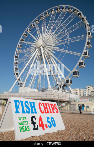 Eine bunte Fische und Späne anmelden Brighton Beach mit The Brighton Wheel (Riesenrad) auf Brighton, East Sussex, England. Stockfoto