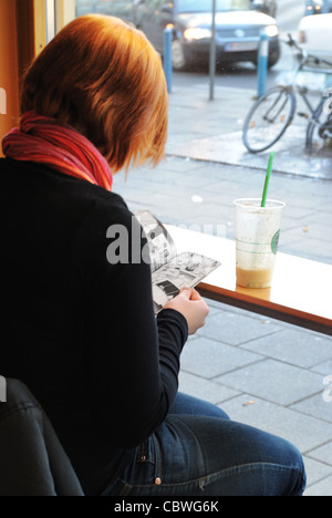 Mädchen lesen Comics in einem Café in Wien, Österreich Stockfoto