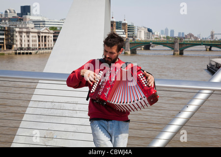 Straßenmusiker spielen Akkordeon auf die Millennium Brücke, London. Stockfoto