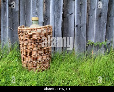 Korb mit Flasche auf grüne Kraut Stockfoto