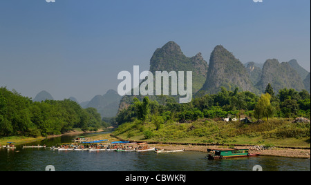 Tour Boot Boote am Ufer des Flusses Li Guangxi Peoples Republic Of China mit Karst Berggipfeln Stockfoto