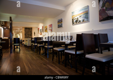 Interieur mit Stühlen und Tischen an der Wand entlang. Stockfoto