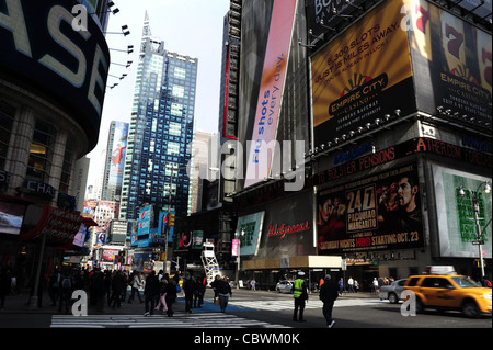 Blauer Himmelsblick Richtung Bertelsmann Gebäude, Menschen, Verkehr Polizist, gelbe Auto West 42nd Street 7th Avenue kreuzen, New York Stockfoto