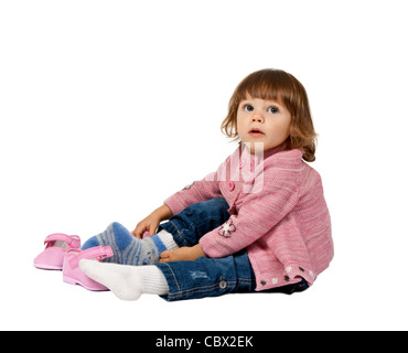 kleines Mädchen trägt Schuhe auf einem weißen Boden im studio Stockfoto