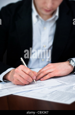 Geschäftsdokumente auf einem Schreibtisch ausfüllen Stockfoto