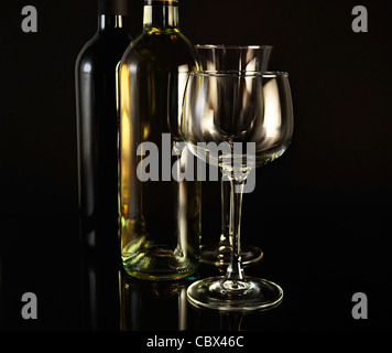 rote und weiße Flaschen Wein auf schwarzem Hintergrund Stockfoto