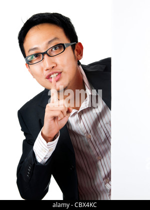 Asiatischer Mann mit leeren Brett, Finger auf die Lippen Stockfoto