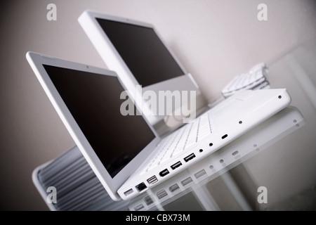 Modernen Arbeitsplatz. Moderne Eleganz weißer Laptop und Computer auf einem Glasschreibtisch. Stockfoto