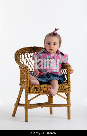 Kleinkind auf Stuhl sitzend Stockfoto