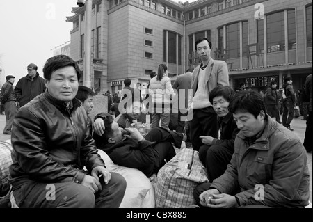 Beijing. Wanderarbeiter warten auf einen Zug auf dem Vorplatz der Beijing Railway Station. Stockfoto