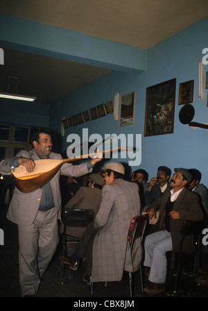 Kurdische Männer in einem Teehaus in Kars, hören Sie ein Troubador (Asik) ein traditionelle hölzerne saitige Saz oder Baglama Instrument zu spielen Stockfoto