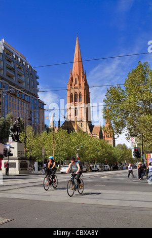 Kreuzung von Collins und Swanston Street, Melbourne. Radfahrer auf belebten Straßen mit St Pauls Cathedral im Hintergrund Stockfoto