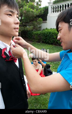 Peking, Chaoyang Park. Fotograf und Bräutigam, mit in den Hintergrund Braut und Make-up-Künstler, Vorbereitung für eine Hochzeit Foto s Stockfoto