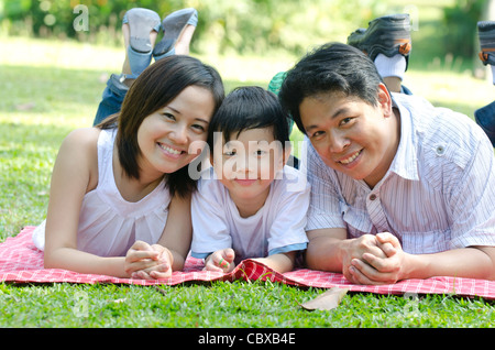 Asiatischen Outdoor-Familie auf der grünen Wiese liegend Stockfoto