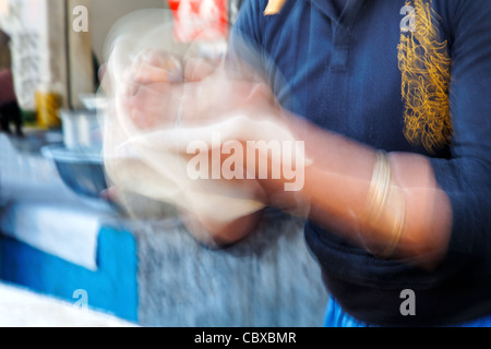 Bewegungsunschärfe schnelle Hände machen ein Naan indisches Fladenbrot in einer Jammu Kaschmir am Straßenrand Hütte nördlichen indischen Koch Stockfoto