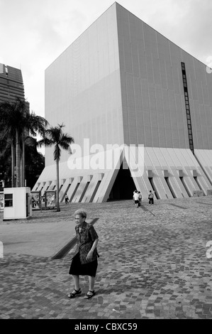 Kowloon, Hong Kong. Frau zu Fuß auf dem Platz vor dem Hong Kong Cultural Centre. Stockfoto