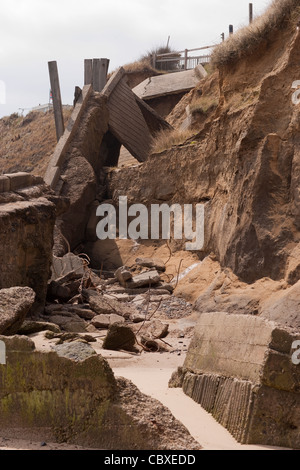 Happisburgh, North Norfolk. Brach zusammen und zerstörten Ufermauer erodiert durch kontinuierliche Stampfen der Nordsee Wellen Stockfoto