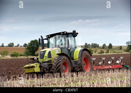 Pflügen mit einem Claas 640 Axion Stoppeln und 5 Furche reversible Pflug Stockfoto