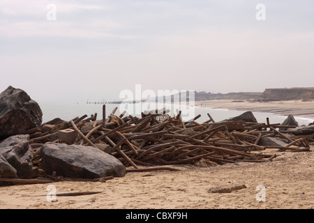 Happisburgh Küste, North Norfolk. Erodiert und zerstörten Metall Brakewaters angesammelt am Strand. Stockfoto