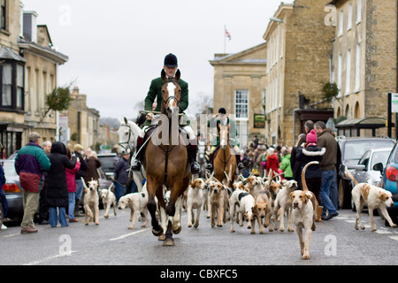 Fox-Hounds als Führung durch das Dorf Chipping Norton vom Meister der Jagd auf einem Pferd für den Boxing Day treffen Stockfoto