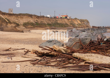 Happisburgh Strand und Klippen, North Norfolk. Flut zerstört Metall Brakewaters gegen importierter Granitfelsen angesammelt. Stockfoto