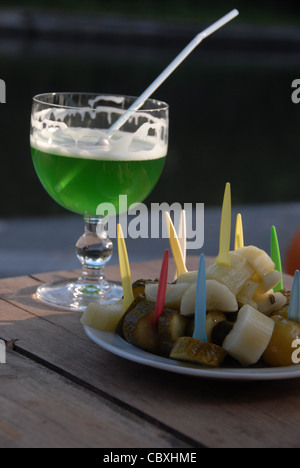 Berliner Weiße, ein Bier Mix mit grünen Waldmeister Limonade, serviert mit Gurken und Essiggurken als erfrischende deutschen Sommer Snack Stockfoto