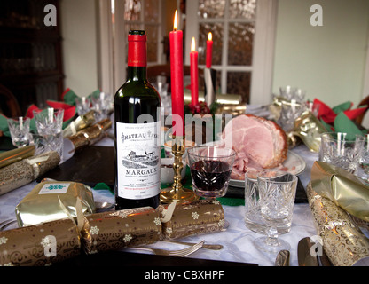 Claret, Kerzen und Knallbonbons auf einem traditionellen britischen Weihnachtsabendtisch, Großbritannien Stockfoto