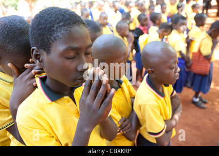 Studenten beten während Schulversammlung in Morogoro, Tansania, Ostafrika. Stockfoto