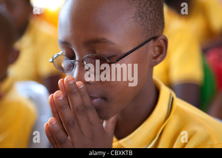 Studenten beten während Schulversammlung in Morogoro, Tansania, Ostafrika. Stockfoto