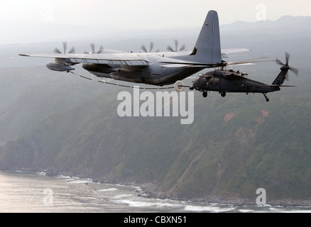 Ein HH-60G-Pave Hawk der 33. Rettungsschwader erhält während eines dreitägigen Intensivkurs am 24. März auf der Kadena Air Base, Japan, Treibstoff von einem MC-130. Piloten der 33. RQS haben ein Tanken-Trainingsprogramm für japanische Self Defense Force Helikopter-Piloten zusammengestellt, um ihnen die Werkzeuge für die Durchführung von Rettungseinsätzen über große Reichweite zur Verfügung zu stellen. Stockfoto