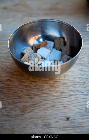 Würfelzucker in Schüssel auf Tisch Stockfoto