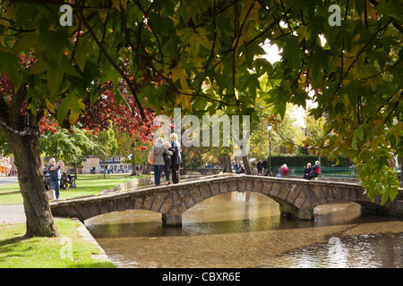 Touristen posieren für Fotos in der Cotswold-Dorf Bourton auf dem Wasser, Gloucestershire Stockfoto