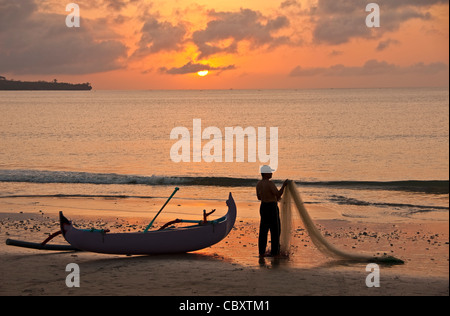 Fischer am Strand von Jimbaran bei Sonnenuntergang, Bali, Indonesien. Stockfoto