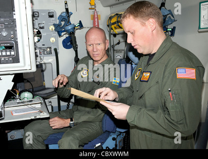 Schwedischer 1. LT. Harry Johansson und U.S. Air Force Staff Sgt. Todd Perkins, C-17 Globemaster III-Lademaster, die dem Schwerlastflügel des Flugstützpunktes Pápa, Ungarn, zugewiesen wurden, gehen vor dem Abflug der Ramstein Air Base, Deutschland, am 18. August eine Checkliste für die Vorfahrt durch. Die HAW, die aus 12 Nationen besteht, arbeitet unabhängig vom militärischen Kommando der NATO und wurde geschaffen, um Nationen dabei zu helfen, globale REACH-Verpflichtungen zu erfüllen Stockfoto