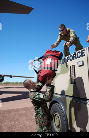 Senior Airman Shawn Pate übergibt Feuerausrüstung an den führenden Flugzeugführer der Royal Australian Air Force Liam Varley, Juli 19, im Bradshaw Field Training Area, Australien. LAC Varley lädt die Ausrüstung auf einem E-One Titan Feuerwehrmotor als Teil von Talisman Sabre 2009. Airman Pate ist ein Feuerwehrmann der 3. Zivilingenieursstaffel der Elmendorf Air Force Base, Alaska. LAC Varley ist ein Rettungsfeuerwehr in der Luftfahrt. Stockfoto