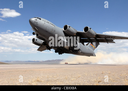 Ein C-17 Globemaster III, der dem 97. Air Mobility Wing, der Luftwaffenbasis Altus, Oklaa, zugewiesen wurde, fliegt vom 20. Mai auf der Landebahn Tonopah auf der Luftwaffenbasis Nellis, Nev., während er an der Übung der Luftstreitkräfte der Mobilität teilnimmt. Etwa 12 US-Luftwaffenstützpunkte nehmen zweimal im Jahr an der Übung Teil und testen die Fähigkeit der Besatzung von C-17 Globemaster IIIs und C-130s, sich zu einem bestimmten Zeitpunkt und an einem bestimmten Ort in Formation zusammenzuschließen, um eine Brigadestärke überall auf der Welt abzusetzen. Stockfoto