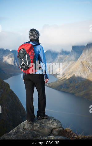 Weibliche Wanderer nimmt im Hinblick auf die dramatische Berglandschaft von Reinebringen, Lofoten Inseln, Norwegen Stockfoto