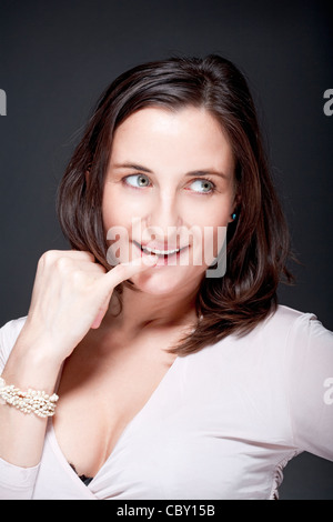 Portrait der schönen Frau mit braunen Haaren auf der Suche - grauen Hintergrund Stockfoto
