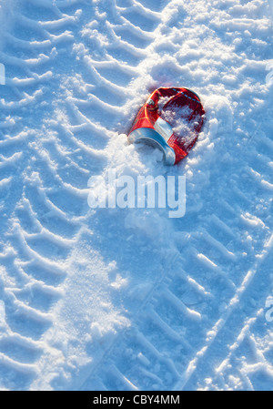 Isolierte zerkleinerte rote Bier kann auf Schnee von Reifenspuren umgeben , Finnland Stockfoto