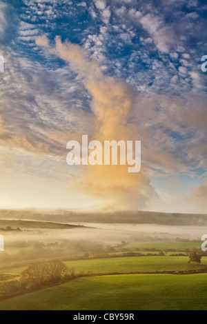Ungewöhnliche Wolkenformation über schwebt über nebligen Felder in den frühen Morgenstunden Stockfoto