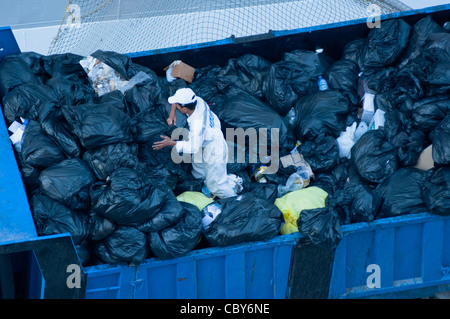 Eine Mann arbeitet mit haufenweise Müll abgeladen von einem großen Kreuzfahrtschiff gerade angedockt. Stockfoto